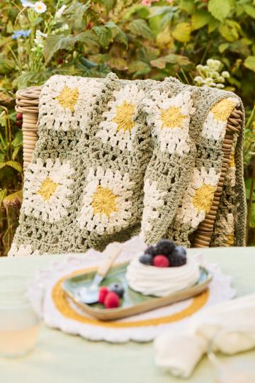 Couverture au crochet vert poussiéreux avec des fleurs blanches et jaunes Ib Laursen