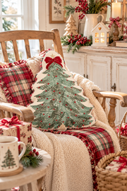 Cuscino natalizio ricamato a forma di albero di Natale con fiocco rosso su poltrona in legno stile cottage inglese.